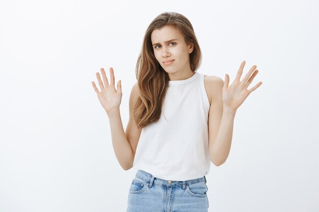 Chica guapa rubia reacia y disgustada evitando problemas, dándose la mano en señal de rechazo, rechazando la oferta