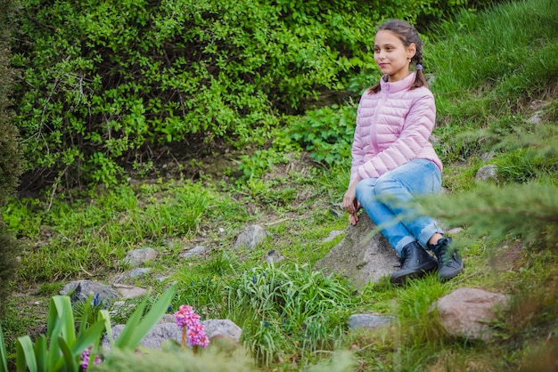 Chica guapa sentada en una piedra