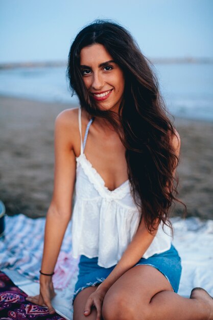 Chica guapa sentada en la playa