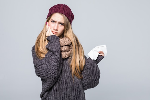 Chica guapa en suéter gris tiene frío tenía dolor de cabeza por gripe en gris