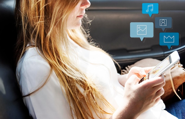 Chica guapa usando su teléfono en un auto