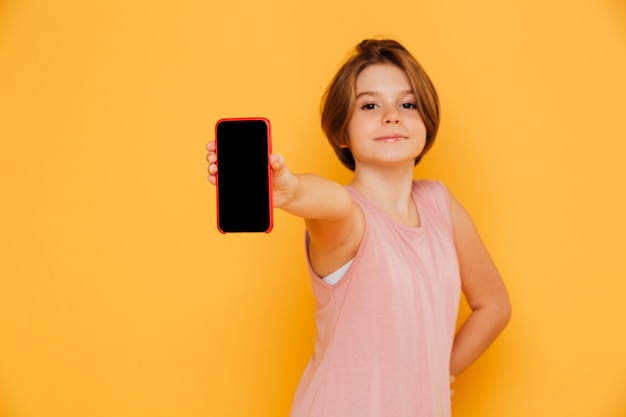 Chica guapo confidente que muestra la pantalla en blanco del teléfono inteligente aislado