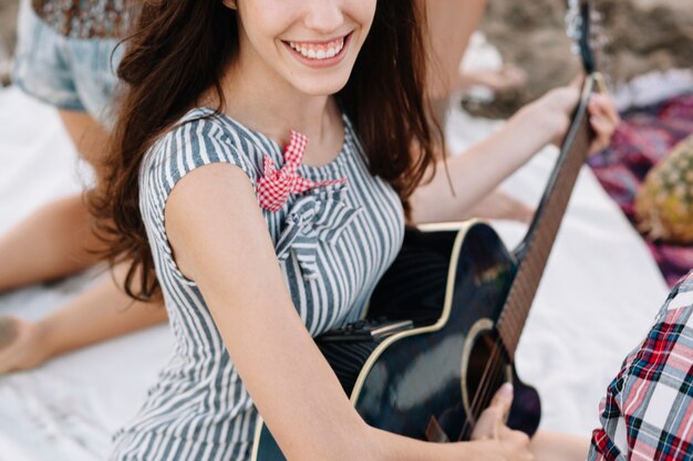 Chica con guitarra por la playa