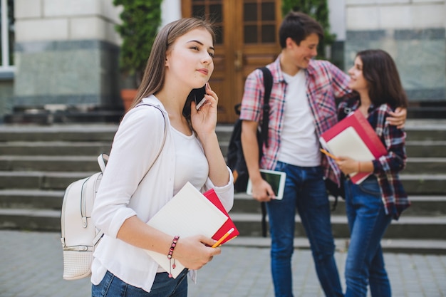 Chica hablando teléfono cerca de la universidad