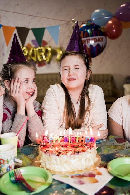 Foto gratuita chica haciendo un deseo en la fiesta de cumpleaños