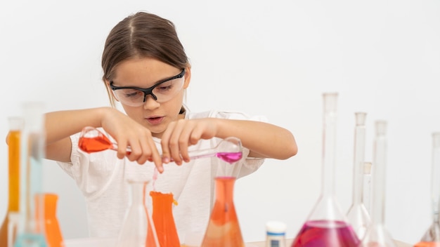 Foto gratuita chica haciendo experimentos de química con gafas de seguridad