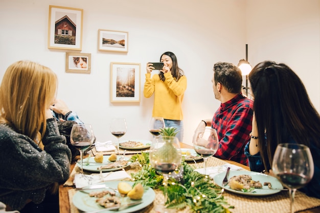 Foto gratuita chica haciendo una foto de amigos cenando