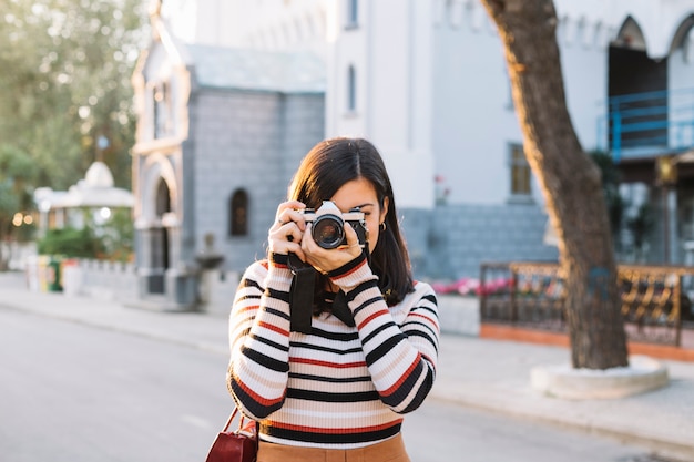 Foto gratuita chica haciendo una foto con cámara de fotos