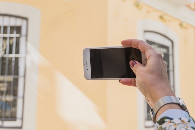 Chica haciendo una foto de una casa amarilla