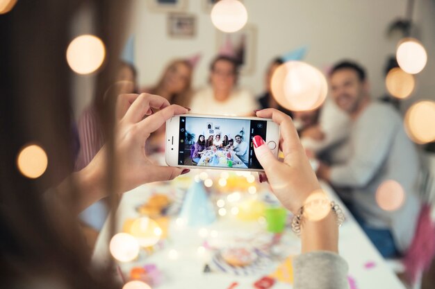 Chica haciendo foto de cumpleaños con smartphone