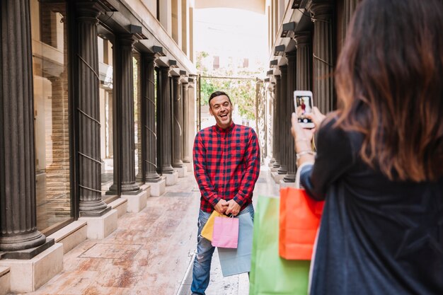 Chica haciendo foto de hombre con smartphone