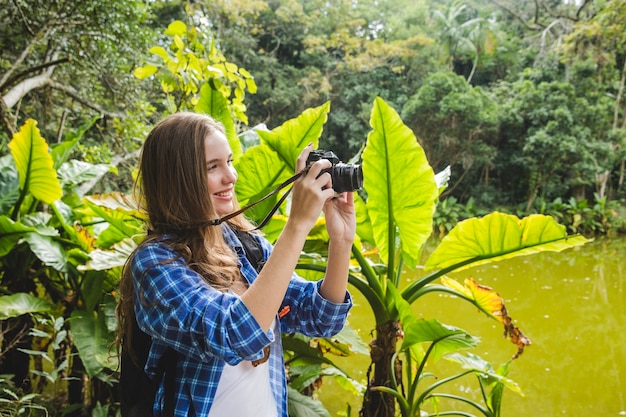 Chica haciendo una foto en la jungla