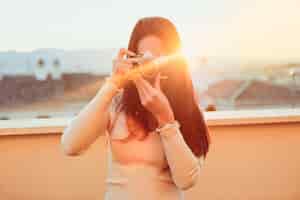 Foto gratuita chica haciendo una foto con su cámara retro