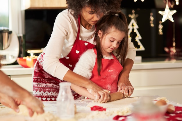 Foto gratuita chica haciendo galletas con mamá