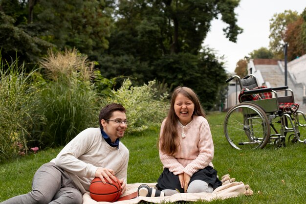 Chica haciendo un picnic con el hombre discapacitado