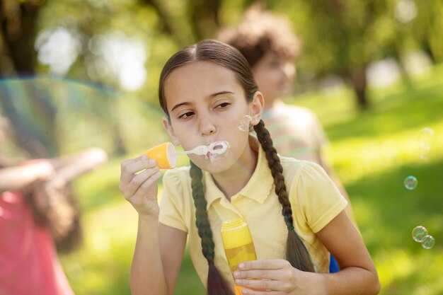 Chica haciendo pompas de jabón en el parque