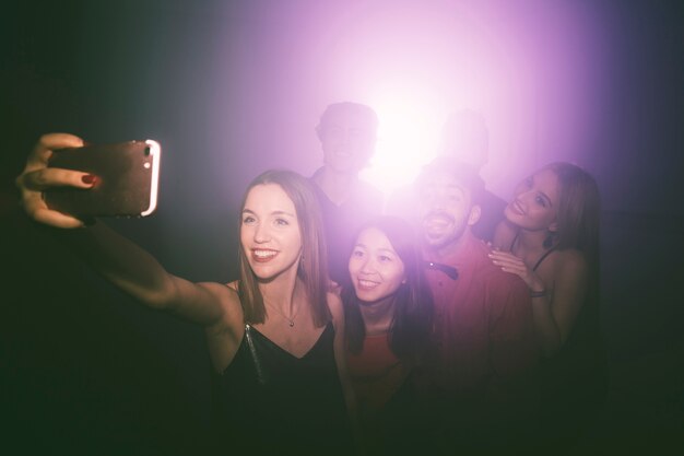 Chica haciendo selfie en discoteca