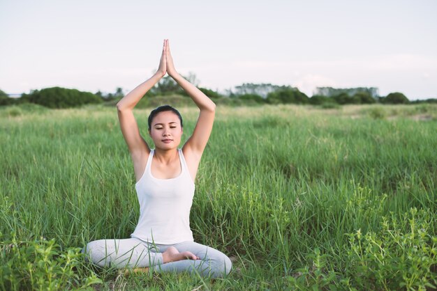 Chica haciendo yoga en el césped