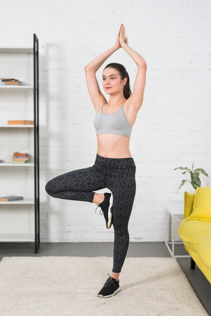 Chica haciendo yoga en su casa