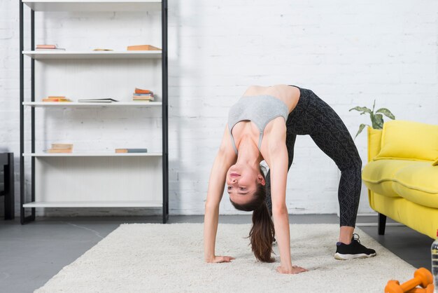 Chica haciendo yoga en su casa