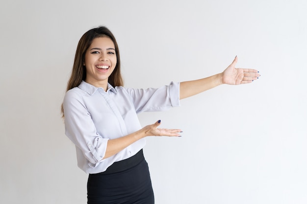 Chica hermosa alegre presentando nuevo producto