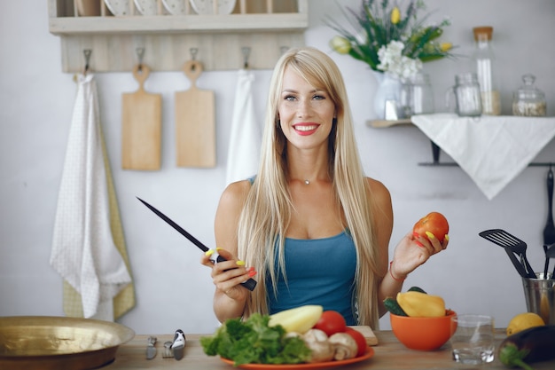 Chica hermosa y deportiva en una cocina con verduras