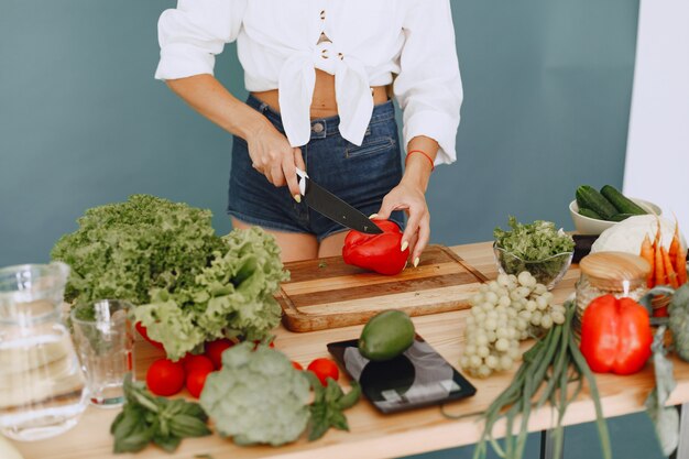 Chica hermosa y deportiva en una cocina con verduras