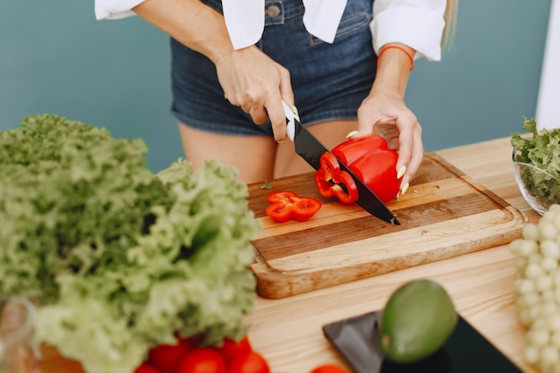 Foto gratuita chica hermosa y deportiva en una cocina con verduras