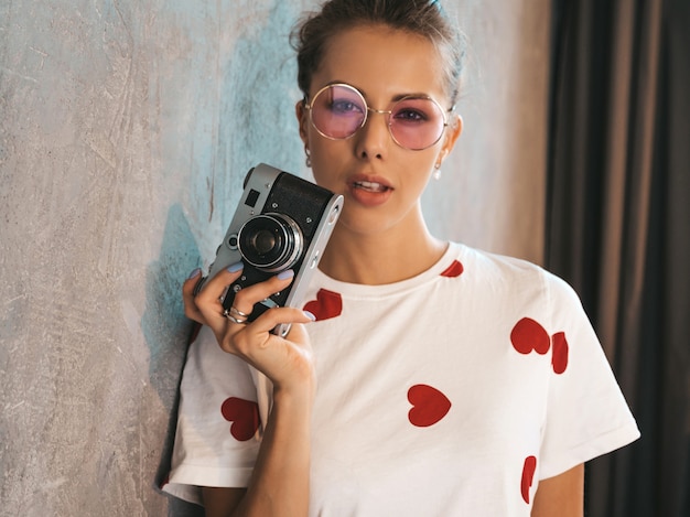 Foto gratuita chica hermosa joven fotógrafo tomando fotos con su cámara retro