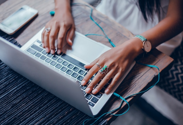 Foto gratuita chica hermosa joven utiliza una computadora portátil en el café, navegar por internet