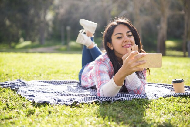 Chica hermosa positiva disfrutando de perfecta conexión inalámbrica