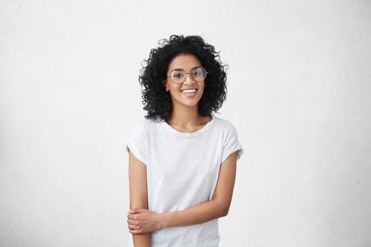 Foto gratuito chica hermosa tímida con cabello negro peludo y piel oscura con gafas de estilo