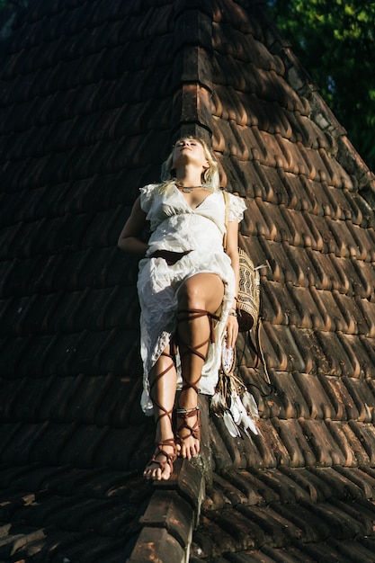 Foto gratuita chica hippie con el pelo largo y rubio en un vestido en el techo.