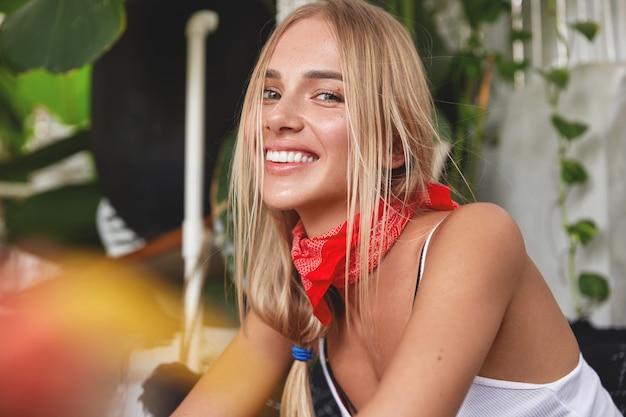 Chica hipster con pañuelo en el cuello posa en café