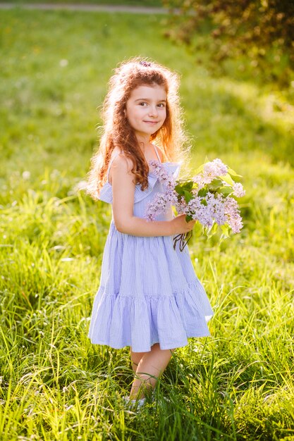 Chica inocente sosteniendo ramo de flores