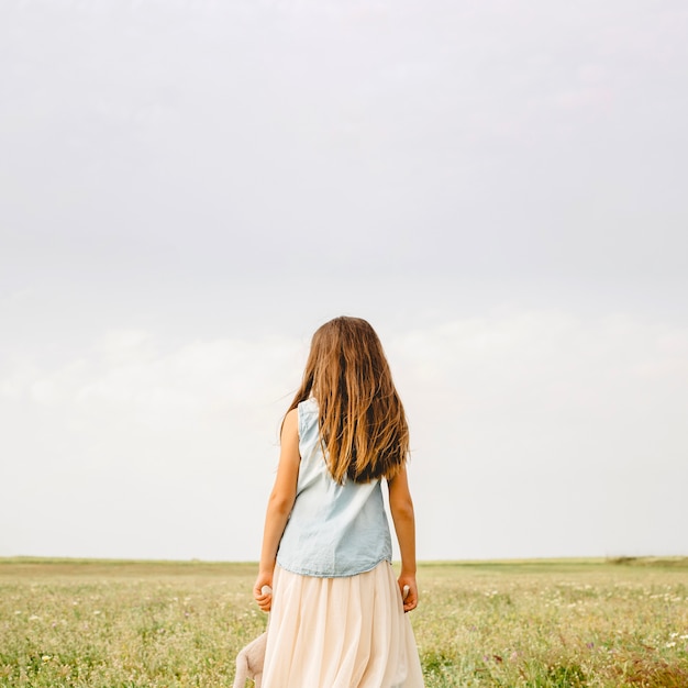 Chica irreconocible de pie en el campo