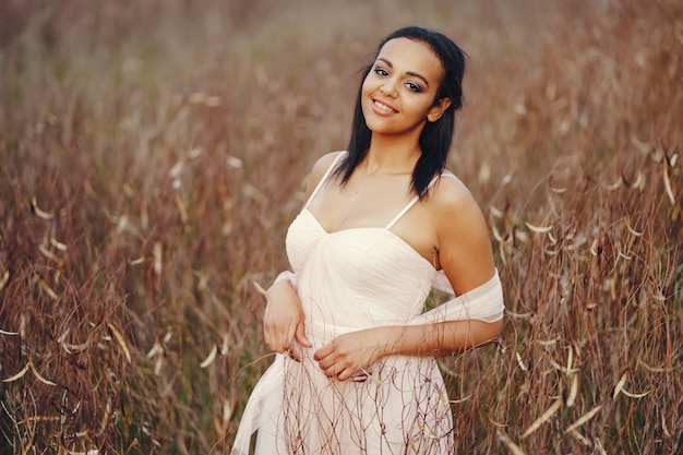 Chica joven afroamericana en el parque en un fondo de la hermosa naturaleza