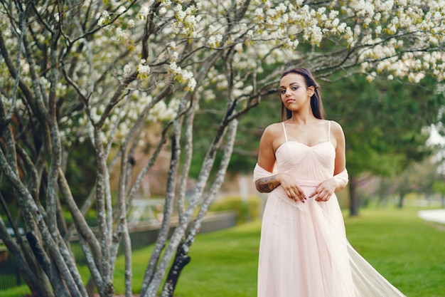 Chica joven afroamericana en el parque en un fondo de la hermosa naturaleza