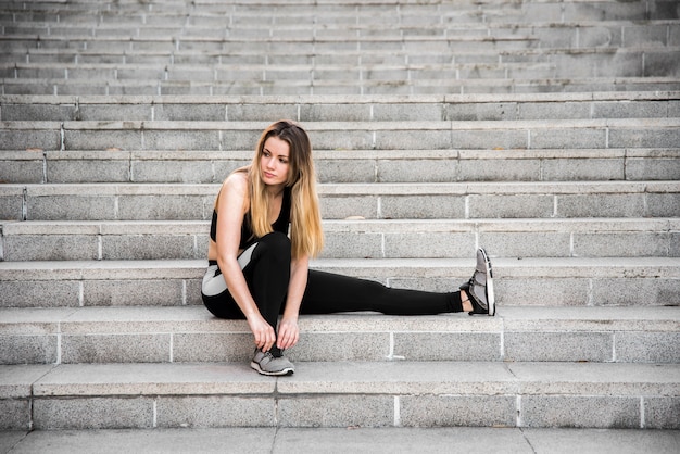 Chica joven atando sus zapatillas de deporte