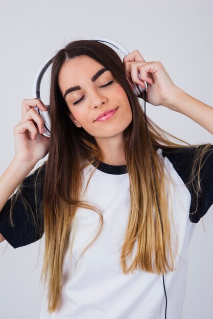 Chica joven bailando con cascos de música