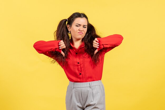 Chica joven en blusa roja mostrando signos distintos en amarillo