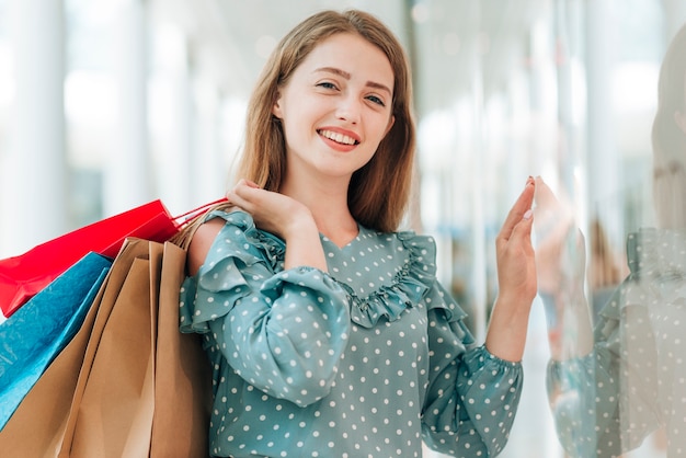 Chica joven con bolsas de compra tiro medio