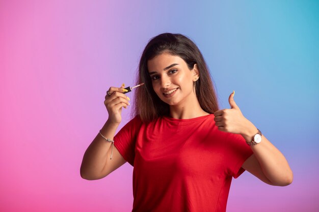 Chica joven en camisa roja aplicando maquillaje.