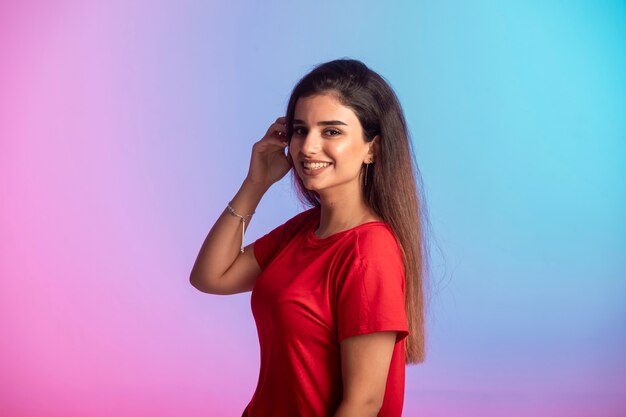 La chica joven con camisa roja se siente positiva.