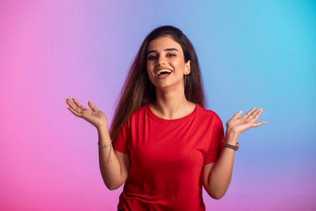 La chica joven con camisa roja se siente positiva.