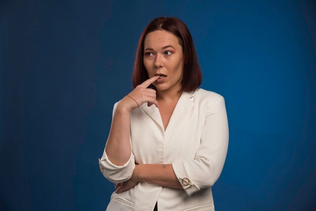 La chica joven con chaqueta blanca parece dudosa.