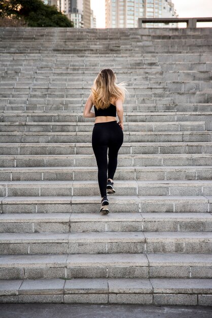 Chica joven corriendo al aire libre con ropa deportiva