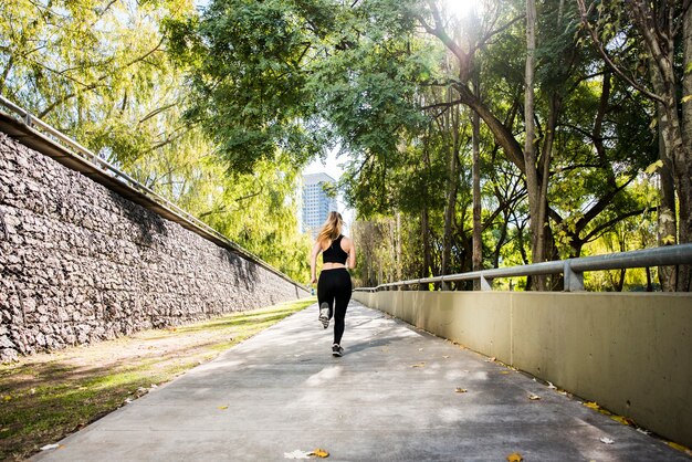 Chica joven corriendo al aire libre con ropa deportiva