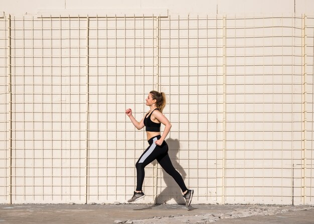 Chica joven corriendo al aire libre con ropa deportiva