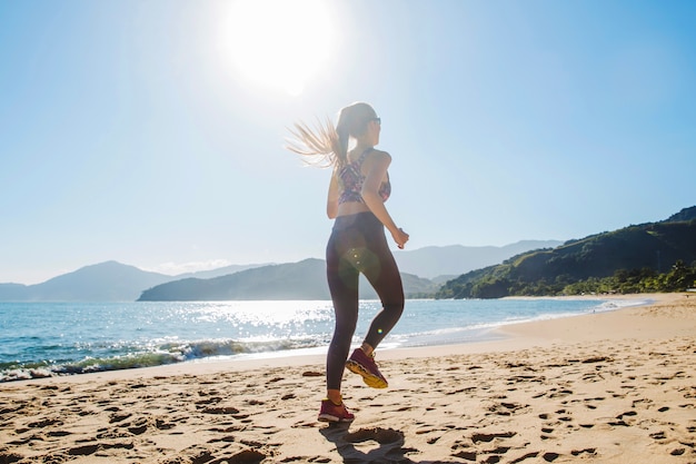 Foto gratuita chica joven corriendo rápido en la playa